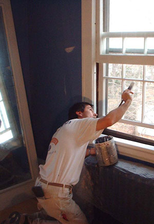 James Bendzinski painting window trim on re-glazed double-hung window